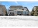 House back view with snowy yard and stone details at 2787 W High Grove Cir, Zionsville, IN 46077