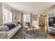 Sunlit living room includes gray sofa, coffee table and hardwood floors at 30 Village Ct, Zionsville, IN 46077