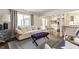 Open living space with a comfy sofa, purple ottoman, and kitchen view at 30 Village Ct, Zionsville, IN 46077
