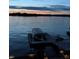 A covered boat dock sits on the tranquil lake, with a jet ski nearby, offering waterfront recreation at 3150 Beach Blvd, Cicero, IN 46034