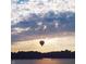 A hot air balloon floats above the water during sunset, creating a picturesque and serene scene at 3150 Beach Blvd, Cicero, IN 46034