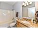 Bathroom with granite countertop, white tub, and decorative accents at 316 Society Dr, Indianapolis, IN 46229