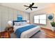 Staged bedroom featuring paneling, a bed with blue accents, and art on the wall at 316 Society Dr, Indianapolis, IN 46229