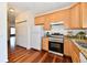 This kitchen area has wood floors and cabinets, stainless steel appliances, and granite countertops at 316 Society Dr, Indianapolis, IN 46229