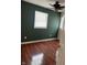 Bedroom with hardwood floors and dark green walls at 3355 Wallace Ave, Indianapolis, IN 46218