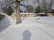 Spacious backyard with snow covering the ground, featuring a large tree and a home in the background at 515 Wedgewood Dr, Anderson, IN 46013