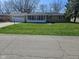 Well-maintained home features a green lawn, attached garage, and sunroom at 515 Wedgewood Dr, Anderson, IN 46013