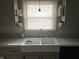 Bright kitchen with farmhouse sink, updated countertops, and window at 515 Wedgewood Dr, Anderson, IN 46013