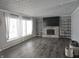 Living room with fireplace, built-in shelves, and large TV at 515 Wedgewood Dr, Anderson, IN 46013