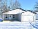 Newly constructed home with a grey exterior, attached garage, and snow-covered yard at 521 N Swain St, Ingalls, IN 46048