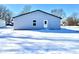 Rear view of a newly built home with grey siding, and snow covered yard at 521 N Swain St, Ingalls, IN 46048