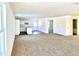 Spacious living room with carpeted floors and views into kitchen and other rooms at 521 N Swain St, Ingalls, IN 46048