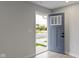 Modern gray front door with glass panels, opening to a light-filled entryway at 6322 Loraine Dr, Brownsburg, IN 46112