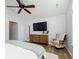 Relaxing bedroom featuring wood floors, ceiling fan, dresser, and large flatscreen TV at 6615 Rushing, Noblesville, IN 46062