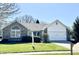Charming single-story home featuring a well-manicured lawn and brick accents at 6615 Rushing, Noblesville, IN 46062