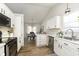 Modern kitchen with white cabinets, stainless steel appliances, and a view of the dining area at 6615 Rushing, Noblesville, IN 46062