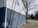 Detail of a two-story house featuring white siding and a dark painted brick foundation at 810 Kendale Ct, Indianapolis, IN 46234