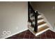 Wooden staircase with black railing and red tile flooring at 810 Kendale Ct, Indianapolis, IN 46234