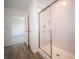 Bathroom featuring a tiled shower with glass doors and walls, and a view to a bedroom at 8798 Walker St, Fortville, IN 46040