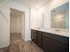 Bathroom featuring double sink vanity, a large mirror, and a view into the closet at 8798 Walker St, Fortville, IN 46040