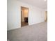Spacious bedroom featuring neutral carpet, white walls, and an ensuite bathroom with wood look flooring at 8798 Walker St, Fortville, IN 46040