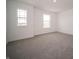 Bright bedroom featuring two windows and neutral carpet and walls at 8798 Walker St, Fortville, IN 46040