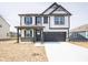 Two-story home with a black-and-white color scheme, front porch, and a two-car garage at 8798 Walker St, Fortville, IN 46040
