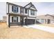 Two-story home with a black and white facade, front porch, and a two-car garage at 8798 Walker St, Fortville, IN 46040