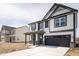 Two-story home with black and white facade, porch, and a two-car garage at 8798 Walker St, Fortville, IN 46040