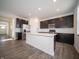 Modern kitchen boasting stainless steel appliances and a central island with dark cabinetry at 8798 Walker St, Fortville, IN 46040