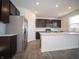Modern kitchen with stainless steel appliances, an island, and dark cabinets provides a functional space at 8798 Walker St, Fortville, IN 46040