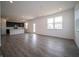 Open-concept living room with gray wood floors that connects to a modern kitchen at 8798 Walker St, Fortville, IN 46040