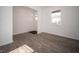 Living room featuring light gray wood-look floors, white walls, and a white door with glass insert at 8798 Walker St, Fortville, IN 46040
