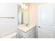 Bathroom with a single sink, white cabinets, and a large mirror with modern lighting at 9217 Hawley Dr, Indianapolis, IN 46216