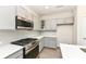 Well-lit kitchen featuring gray cabinets, stainless steel appliances, and an island with a white countertop at 9217 Hawley Dr, Indianapolis, IN 46216