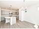 Open-concept living space with an adjacent kitchen, hardwood floors, and modern lighting fixtures at 9217 Hawley Dr, Indianapolis, IN 46216