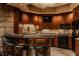 Basement bar with dark wood cabinets, granite counters, and stone backsplash at 11281 Golden Bear Way, Noblesville, IN 46060