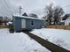 Rear view of a blue house with a snow-covered yard and wooden fence at 1256 Kappes St, Indianapolis, IN 46221