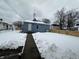 Rear view of a blue house with a snow-covered yard and wooden fence at 1256 Kappes St, Indianapolis, IN 46221