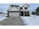 Two-story house with gray brick and white siding, a two-car garage, and a snowy front yard at 13211 N Landing W Cir, Camby, IN 46113