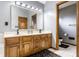 Well-lit bathroom with double sinks, wood cabinetry, and modern fixtures, offering functionality and style at 13955 Springmill Ponds Cir, Carmel, IN 46032