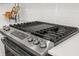 Close-up of a modern gas stovetop with sleek stainless steel finish and white subway tile backsplash at 19349 Sumrall Pl, Westfield, IN 46074