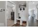 Bright hallway with luxury vinyl plank flooring, coat rack with built-in storage bench, leading into a spacious laundry room at 19365 Sumrall Pl, Westfield, IN 46074