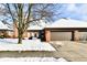 Brick ranch home with attached garage, snow covered landscaping, and a tree in the front yard at 243 Andrews Blvd, Plainfield, IN 46168