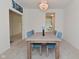 Chandelier hangs over a wooden dining table and upholstered chairs, in a room with neutral walls and carpeting at 4061 Omaha Dr, Bargersville, IN 46106