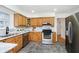 Modern kitchen with wood cabinets, granite counters, and stainless steel appliances at 4367 Central Ave, Indianapolis, IN 46205