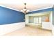Stylish dining area featuring blue walls, white wainscoting, modern light fixture, and open to the living room at 475 Golf Ln, Indianapolis, IN 46260