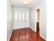 Bright foyer with dark wood floors, white paneled front door, and access to a nearby powder room at 475 Golf Ln, Indianapolis, IN 46260