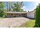 Charming brick ranch with a covered front porch and mature landscaping at 475 Golf Ln, Indianapolis, IN 46260
