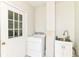 Practical laundry room with a white washer, utility sink, and exterior door, offering convenience for laundry tasks at 475 Golf Ln, Indianapolis, IN 46260
